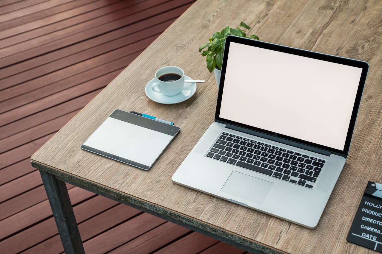 Laptop und Kaffeetasse am Tisch